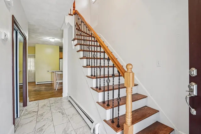 a view of staircase with lots of frames on wall and a window