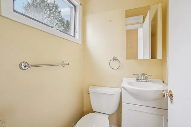 a bathroom with a toilet sink and mirror