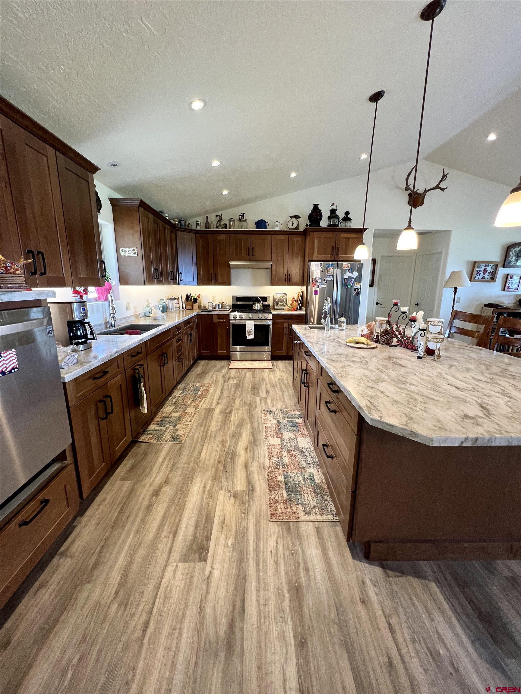 23105 U Road Cedaredge, CO 81413 - Photo 14 of 33 a kitchen with stainless steel appliances granite countertop a sink stove and wooden floor