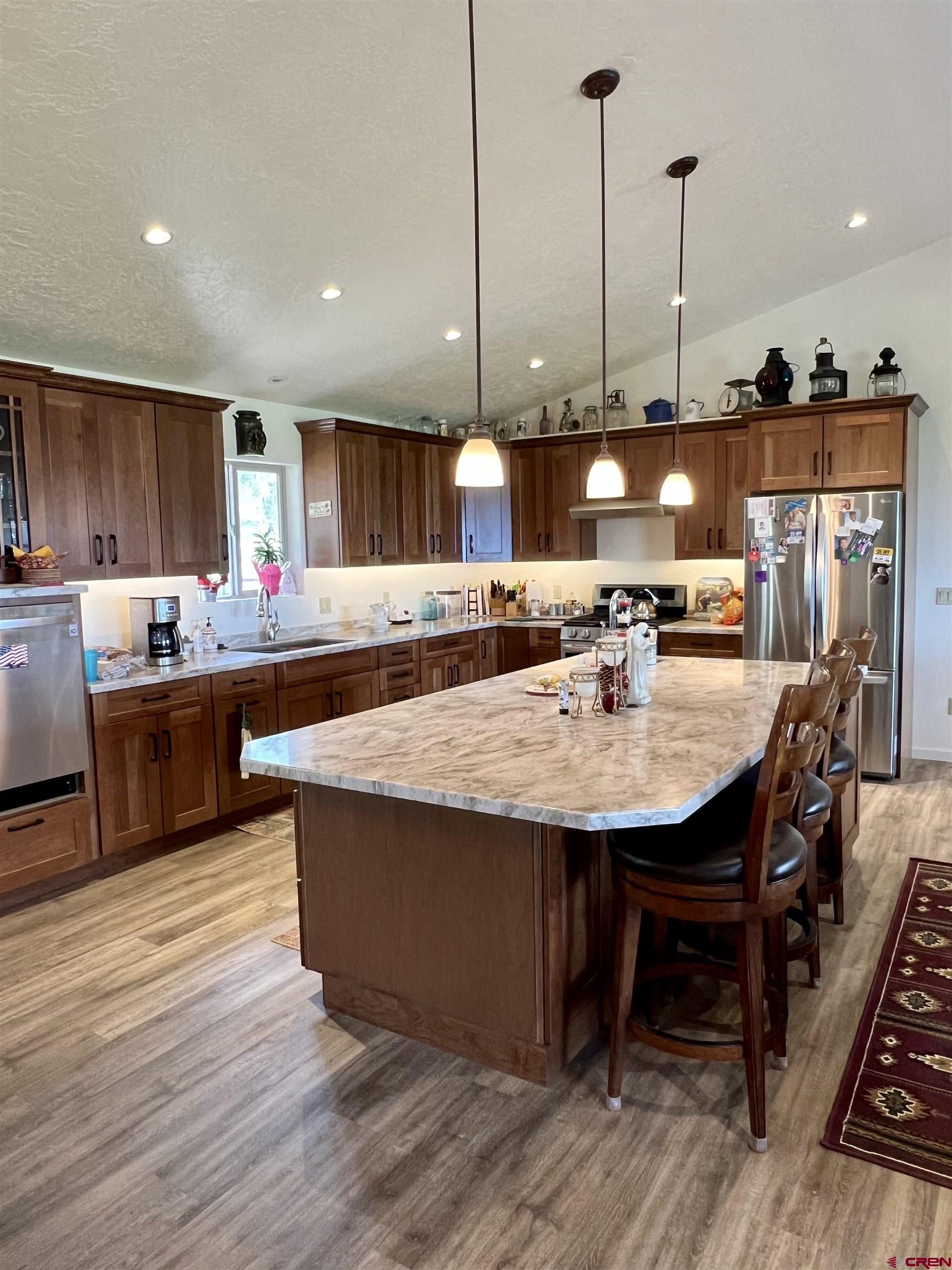 23105 U Road Cedaredge, CO 81413 - Photo 19 of 33 a kitchen with stainless steel appliances kitchen island granite countertop a table chairs and a wooden floors
