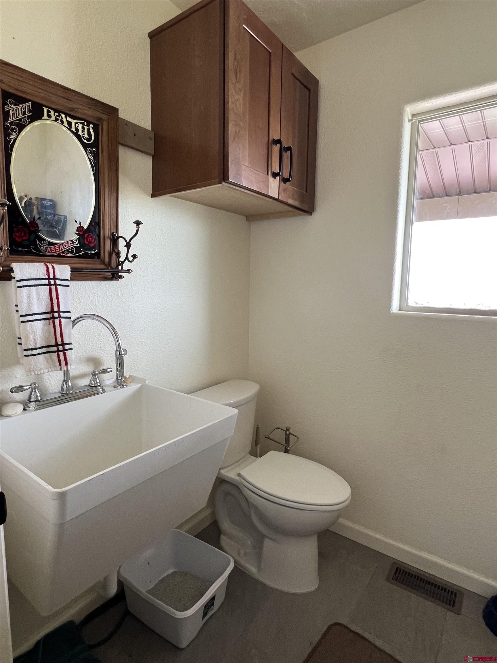 23105 U Road Cedaredge, CO 81413 - Photo 25 of 33 a bathroom with a toilet a sink and mirror