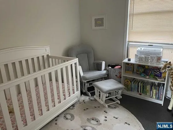 a living room with furniture a baby crib and a chair