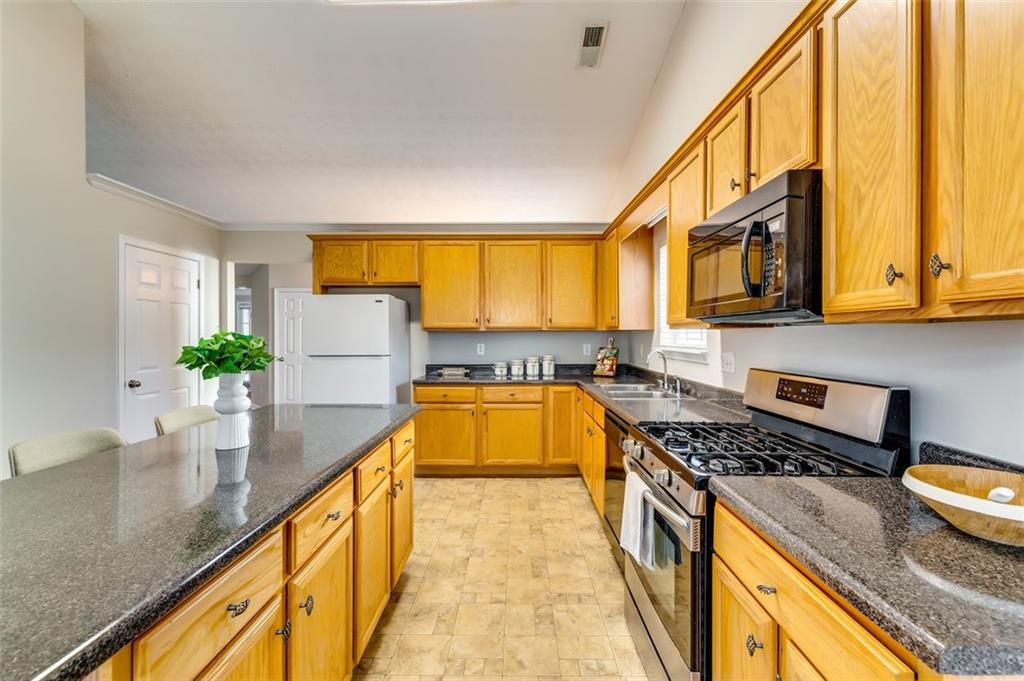 5602 Swanson Road Ellenwood, GA 30294 - Photo 12 of 36 a kitchen with stainless steel appliances granite countertop sink stove and microwave
