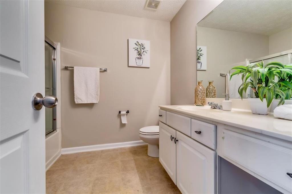 5602 Swanson Road Ellenwood, GA 30294 - Photo 28 of 36 a bathroom with a double vanity sink toilet and a mirror