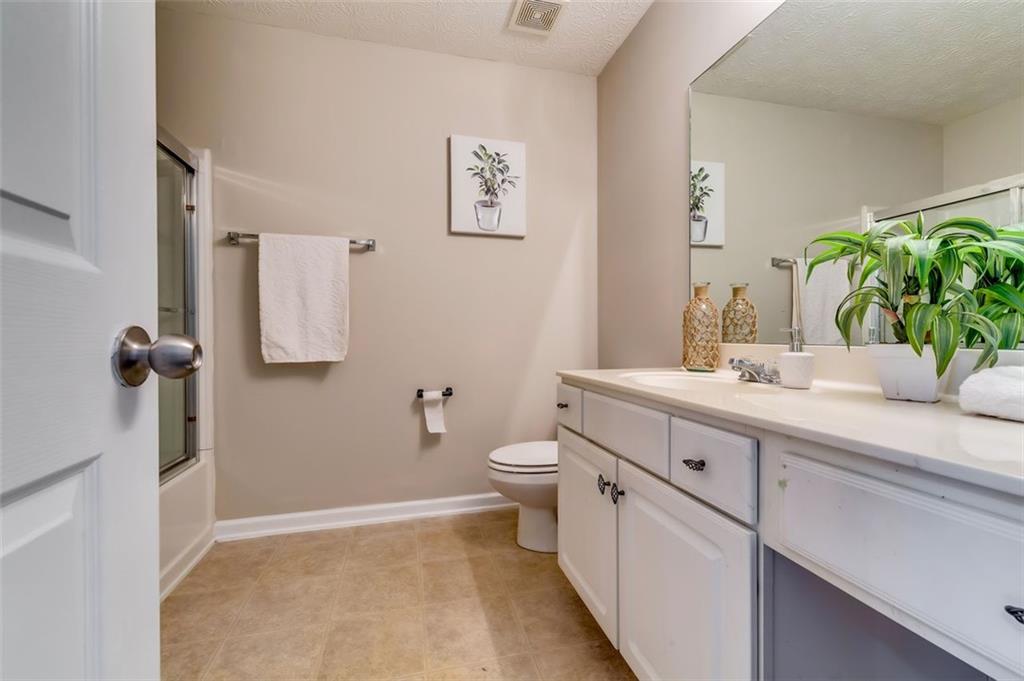 5602 Swanson Road Ellenwood, GA 30294 - Photo 29 of 36 a bathroom with a double vanity sink toilet and a mirror
