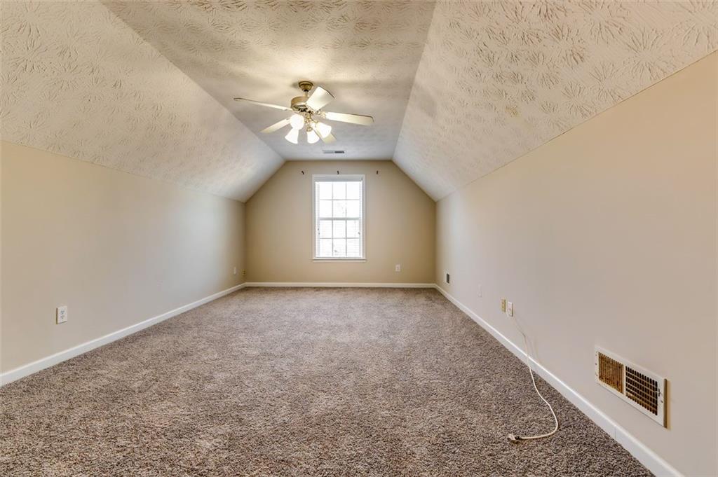 5602 Swanson Road Ellenwood, GA 30294 - Photo 32 of 36 an empty room with a chandelier fan and windows