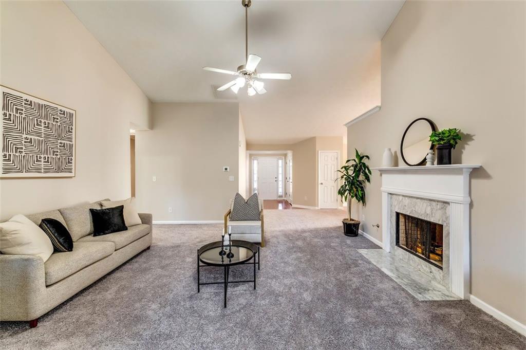 5602 Swanson Road Ellenwood, GA 30294 - Photo 5 of 36 a living room with furniture a chandelier and a fireplace