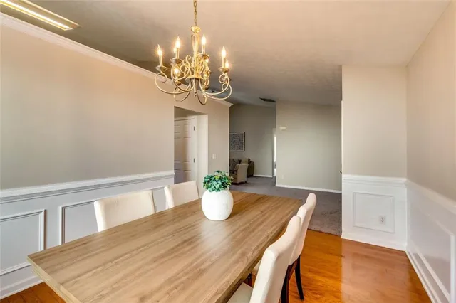 a view of a dining room with furniture a chandelier and wooden floor