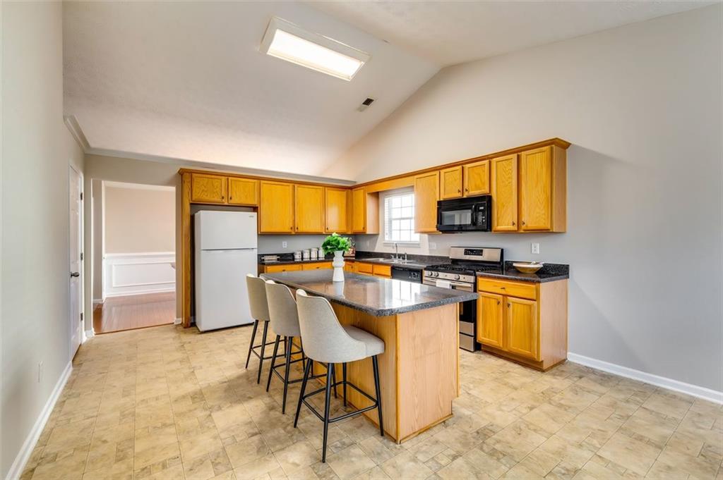 5602 Swanson Road Ellenwood, GA 30294 - Photo 10 of 36 a kitchen with stainless steel appliances granite countertop a stove a sink refrigerator and a microwave