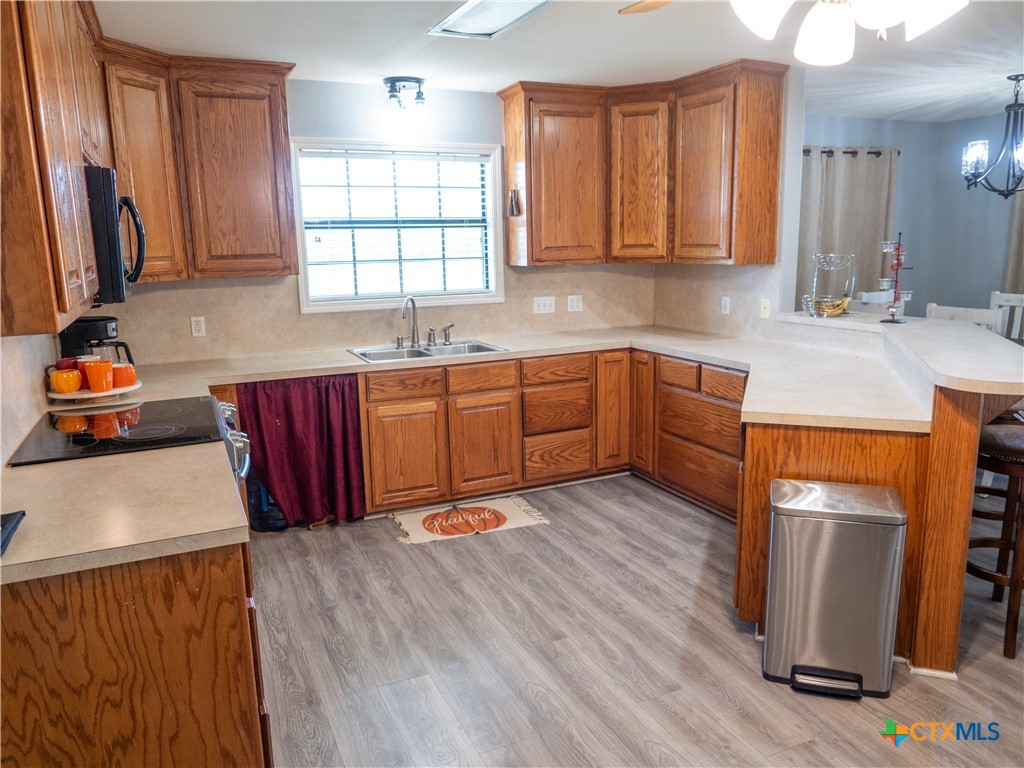 2507 Boyd Road Port Lavaca, TX 77979 - Photo 19 of 47 a kitchen with stainless steel appliances granite countertop wooden cabinets a sink a stove a refrigerator and dishwasher with wooden floor