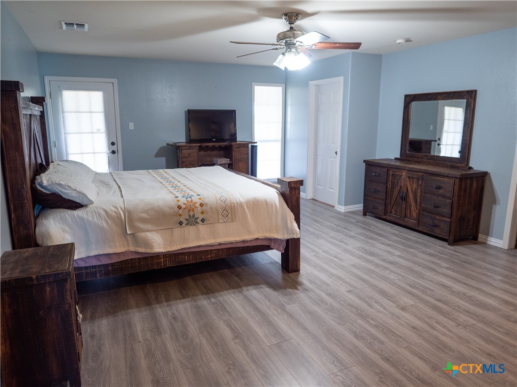2507 Boyd Road Port Lavaca, TX 77979 - Photo 29 of 47 a bedroom with a large bed a chandelier and dresser