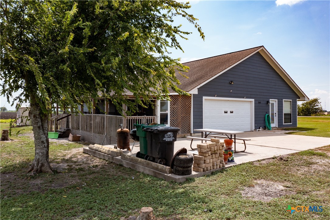 2507 Boyd Road Port Lavaca, TX 77979 - Photo 6 of 47 a view of a backyard with table and chairs potted plants and large tree
