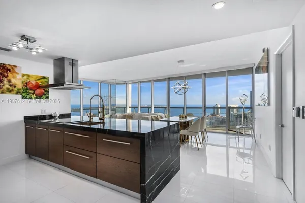 a dining hall with stainless steel appliances granite countertop a sink and cabinets