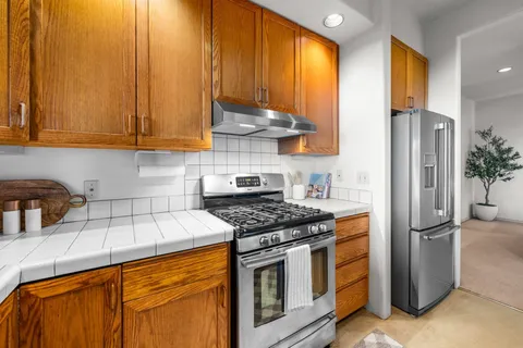 a kitchen with stainless steel appliances granite countertop a stove a refrigerator and a sink