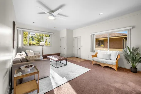 a living room with furniture and a large window with wooden floor
