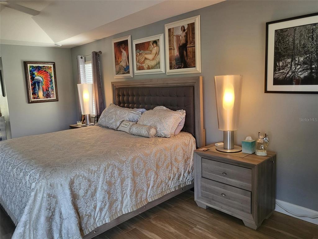 107 Wading Bird Drive Venice, FL 34292 - Photo 11 of 33 a bedroom with a bed and paintings on the wall