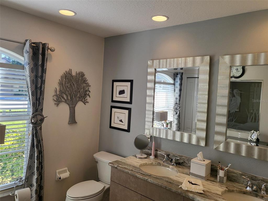 107 Wading Bird Drive Venice, FL 34292 - Photo 18 of 33 a bathroom with a granite countertop sink toilet and mirror