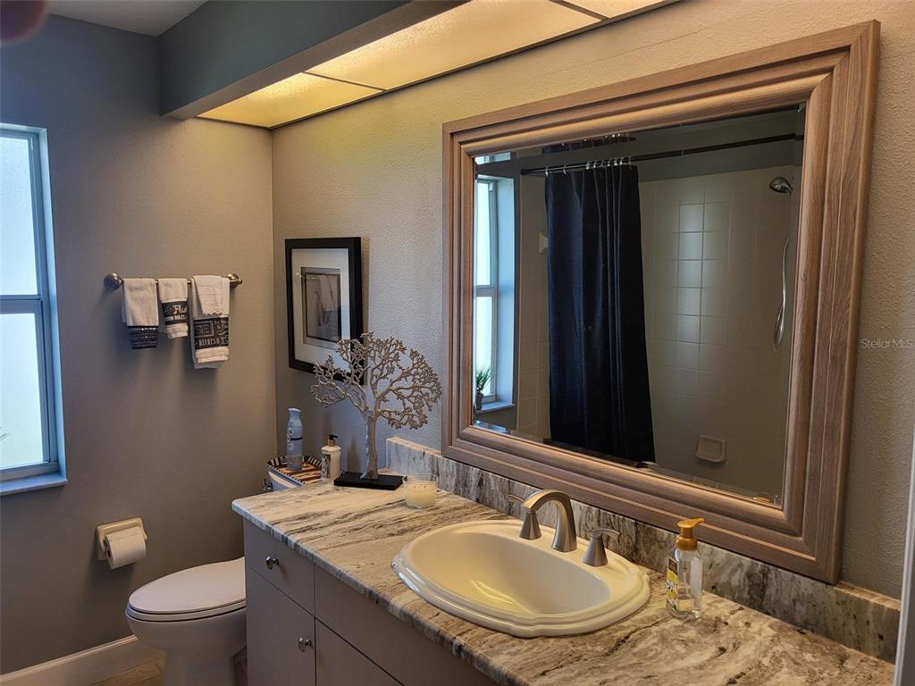 107 Wading Bird Drive Venice, FL 34292 - Photo 21 of 33 a bathroom with a granite countertop sink toilet and mirror