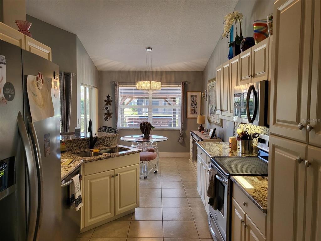 107 Wading Bird Drive Venice, FL 34292 - Photo 7 of 33 a kitchen with stainless steel appliances granite countertop a sink stove and refrigerator