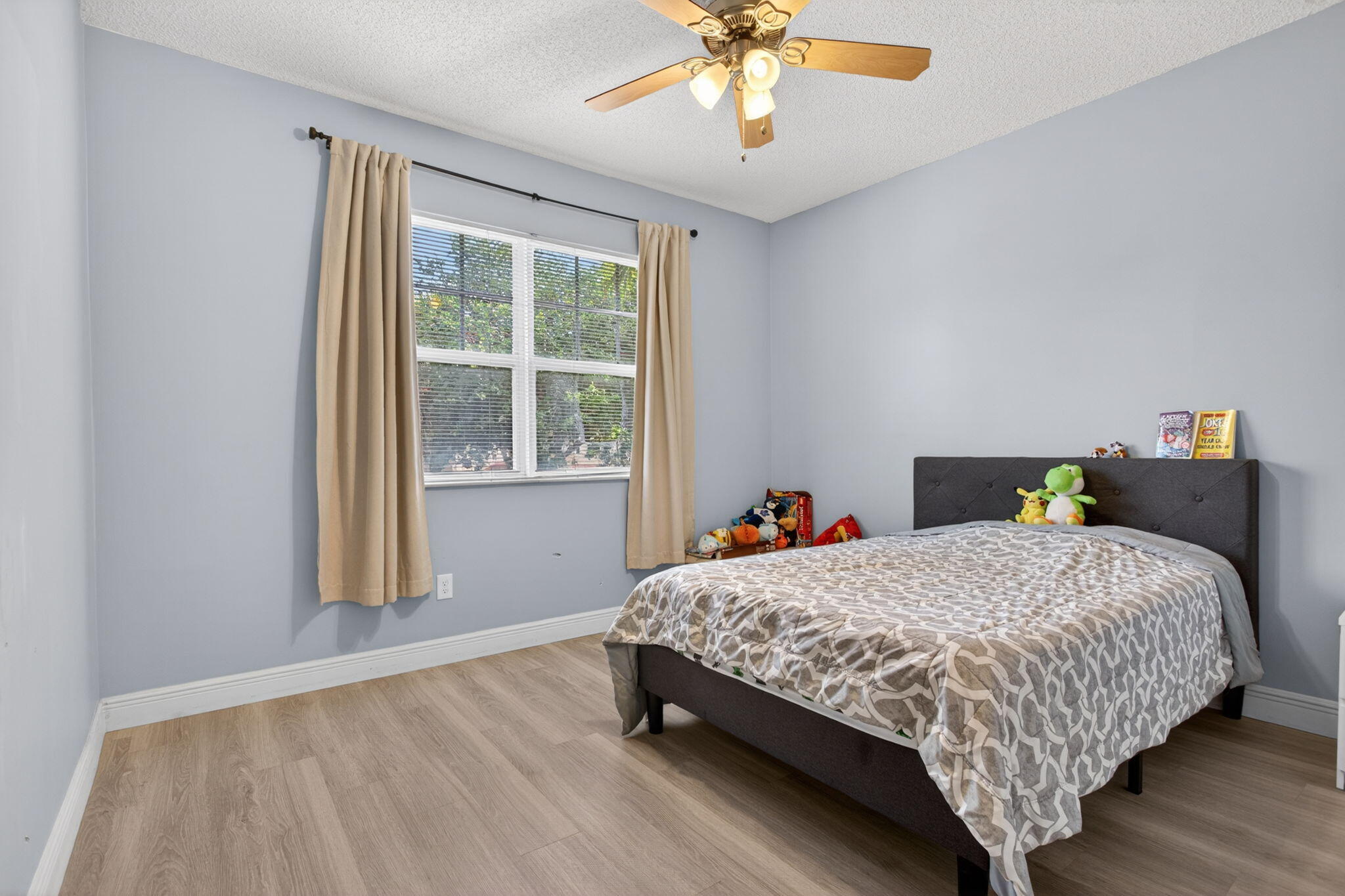 5880 West Sample Road, Unit 206 Coral Springs, FL 33067 - Photo 18 of 37 a bedroom with a bed and a chandelier
