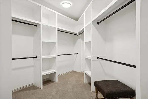 a view of walk in closet with empty racks