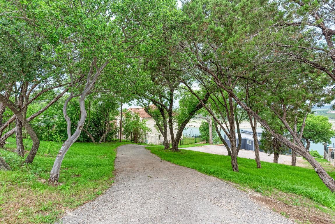 8130 Joy Road Volente, TX 78641 - Photo 3 of 36 View of property's community with driveway and a lawn