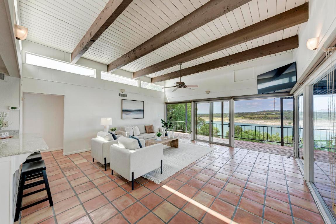 8130 Joy Road Volente, TX 78641 - Photo 9 of 36 Living area featuring light tile patterned floors, healthy amount of natural light, a high ceiling, ceiling fan, and beam ceiling