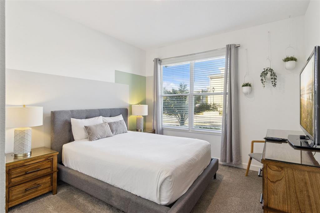 4378 Rhyme Street Kissimmee, FL 34746 - Photo 17 of 41 a bedroom with a bed and a flat tv screen on the dresser