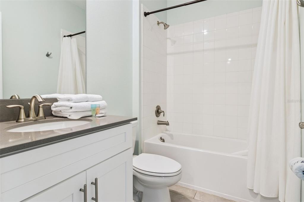 4378 Rhyme Street Kissimmee, FL 34746 - Photo 22 of 41 a bathroom with a granite countertop sink toilet and shower
