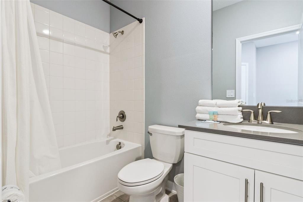 4378 Rhyme Street Kissimmee, FL 34746 - Photo 23 of 41 a bathroom with a granite countertop toilet sink and a bathtub