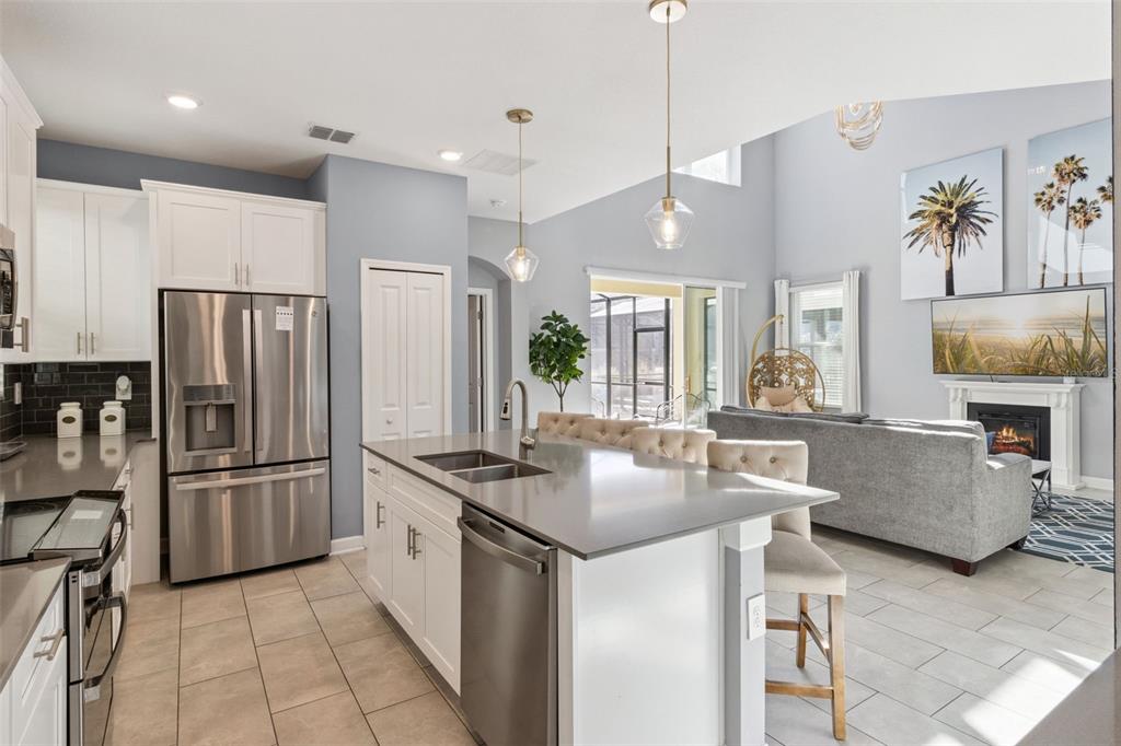 4378 Rhyme Street Kissimmee, FL 34746 - Photo 9 of 41 a kitchen with stainless steel appliances granite countertop a refrigerator a sink and a stove