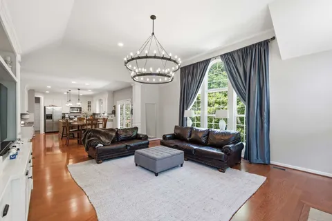 a living room with furniture chandelier and a large window