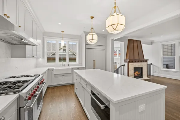 a kitchen that has a stove a sink a window and a dining table