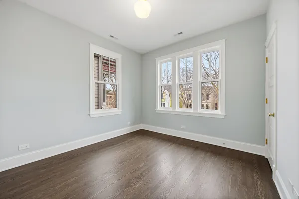 an empty room with wooden floor and stairs