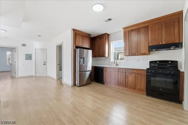 a kitchen with stainless steel appliances a refrigerator and a stove top oven