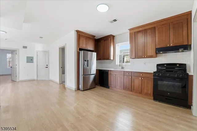 a kitchen with stainless steel appliances a refrigerator and a stove top oven