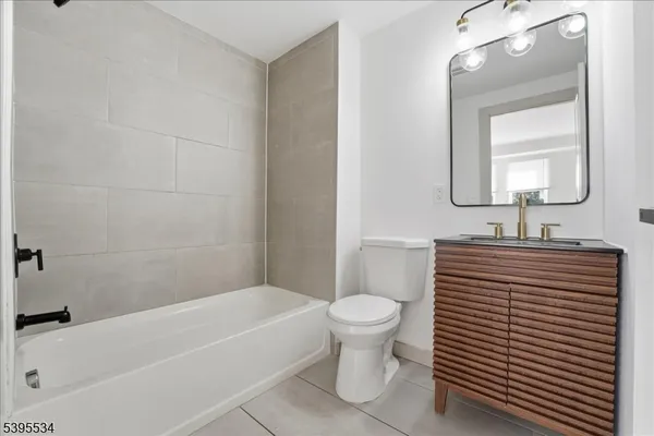 a bathroom with a sink a toilet a mirror and bathtub