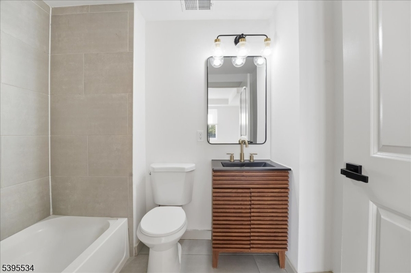 260 South 10th Street, Unit 2 Newark, NJ 07103 - Photo 12 of 26 a bathroom with a toilet sink and mirror