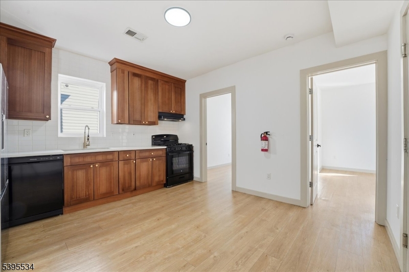 260 South 10th Street, Unit 2 Newark, NJ 07103 - Photo 2 of 26 a kitchen with granite countertop a refrigerator and cabinets