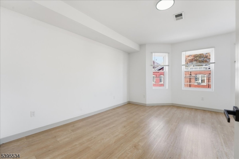 260 South 10th Street, Unit 2 Newark, NJ 07103 - Photo 21 of 26 an empty room with wooden floor and windows