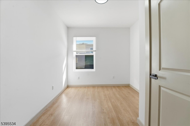 260 South 10th Street, Unit 2 Newark, NJ 07103 - Photo 23 of 26 a view of an empty room with wooden floor and a window