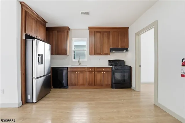 a kitchen with stainless steel appliances granite countertop a refrigerator a stove a sink and a microwave