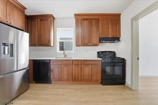 a kitchen with stainless steel appliances granite countertop a refrigerator stove and sink