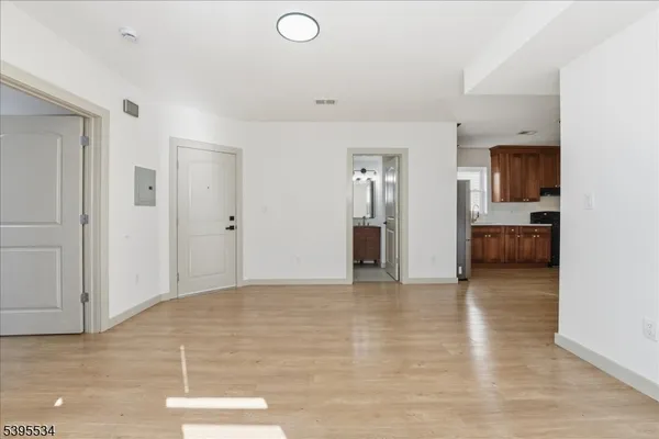a view of empty room with kitchen and window