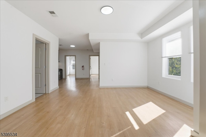 260 South 10th Street, Unit 2 Newark, NJ 07103 - Photo 7 of 26 a view of a hallway with wooden floor and a living room