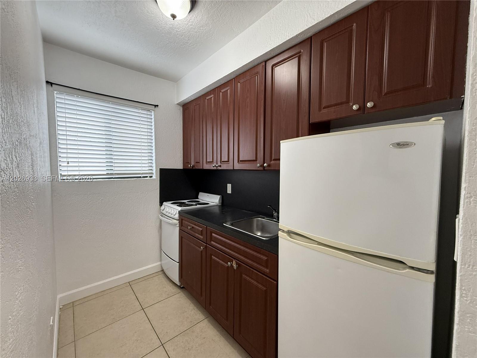 421 Southwest 6th Street, Unit 7 Miami, FL 33130 - Photo 3 of 8 a kitchen with granite countertop cabinets and refrigerator