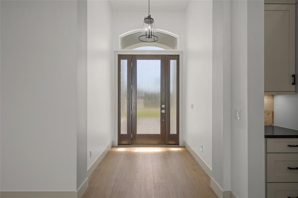 504 Gulf Street Venice, FL 34285 - Photo 6 of 47 a view of a hallway with wooden floor and a chandelier