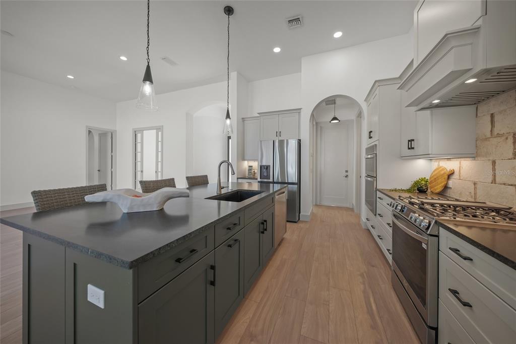 504 Gulf Street Venice, FL 34285 - Photo 10 of 47 a kitchen with stainless steel appliances granite countertop a lot of counter space and wooden floors