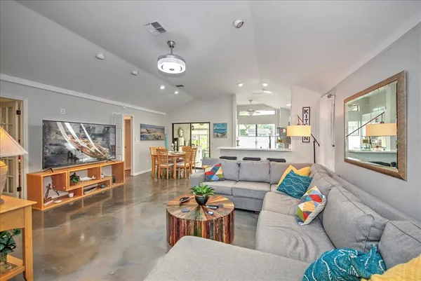 a living room with furniture kitchen view and a large window