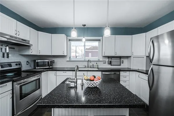 a kitchen with stainless steel appliances granite countertop a sink stove and refrigerator